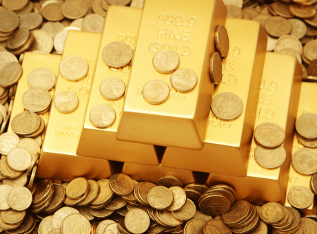 Gold bars and gold coins representing investment assets, illustrating UK tax rules on whether gold coins are exempt from Capital Gains Tax.